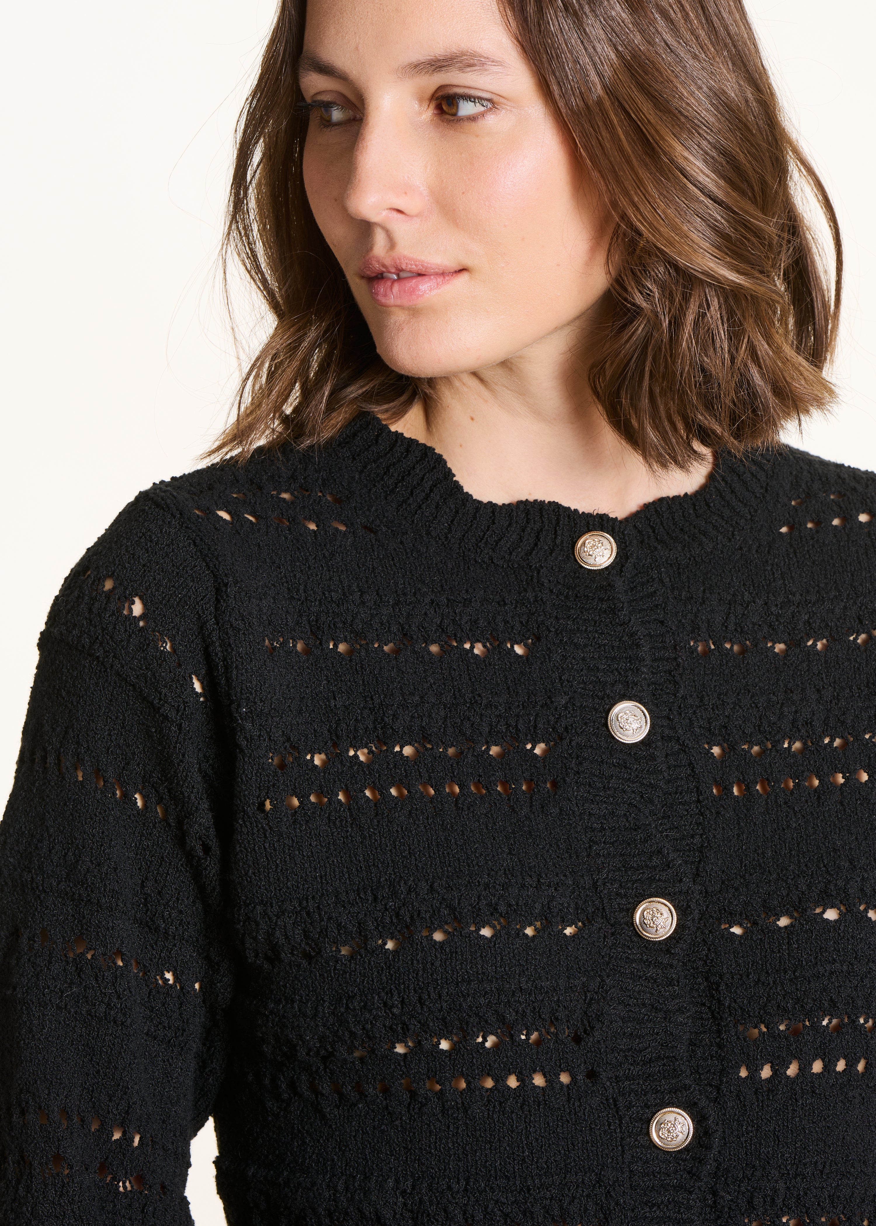 Schwarze Strickweste mit Lochmuster und Zierknöpfen