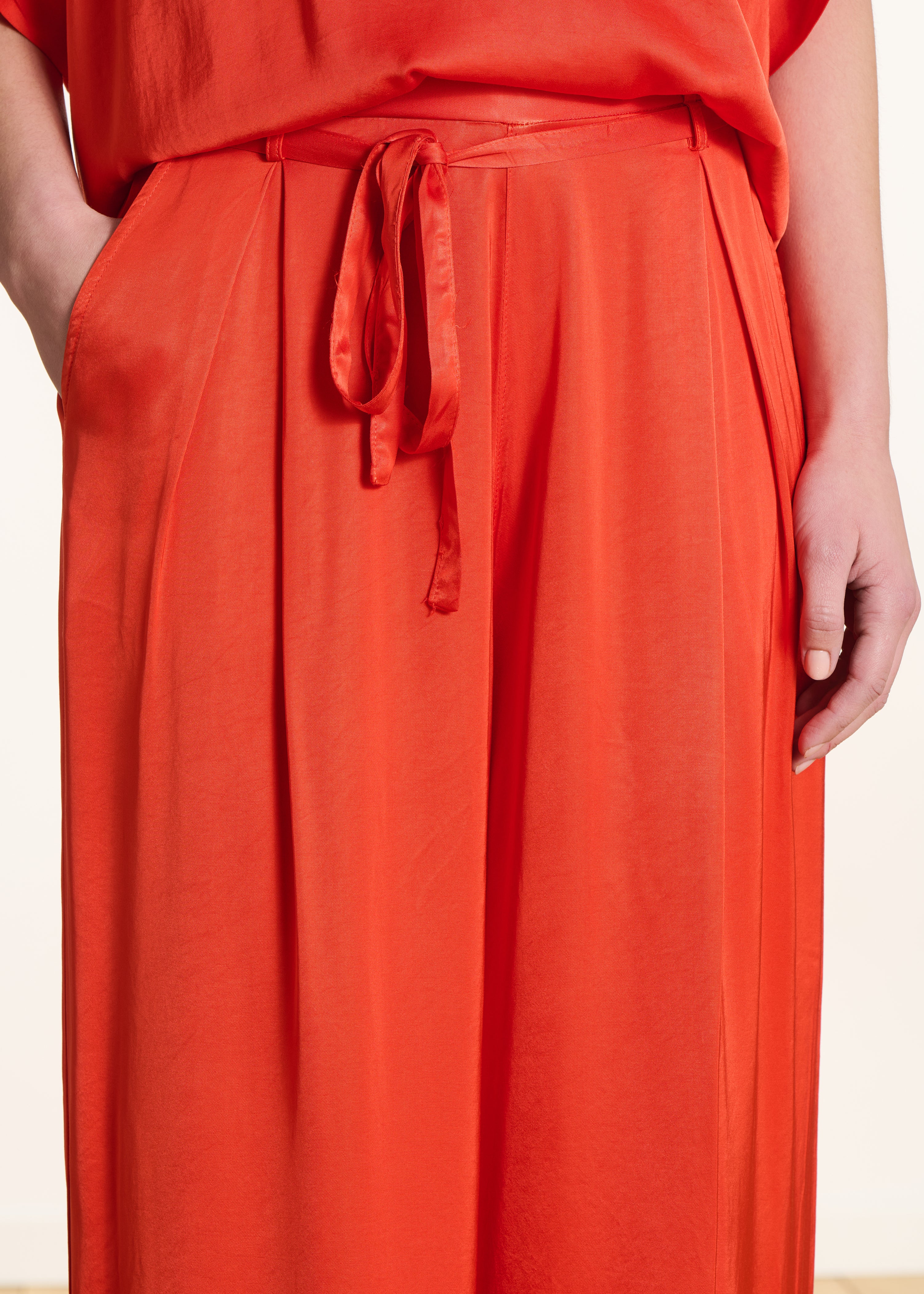 Wide high-waisted orange satin trousers