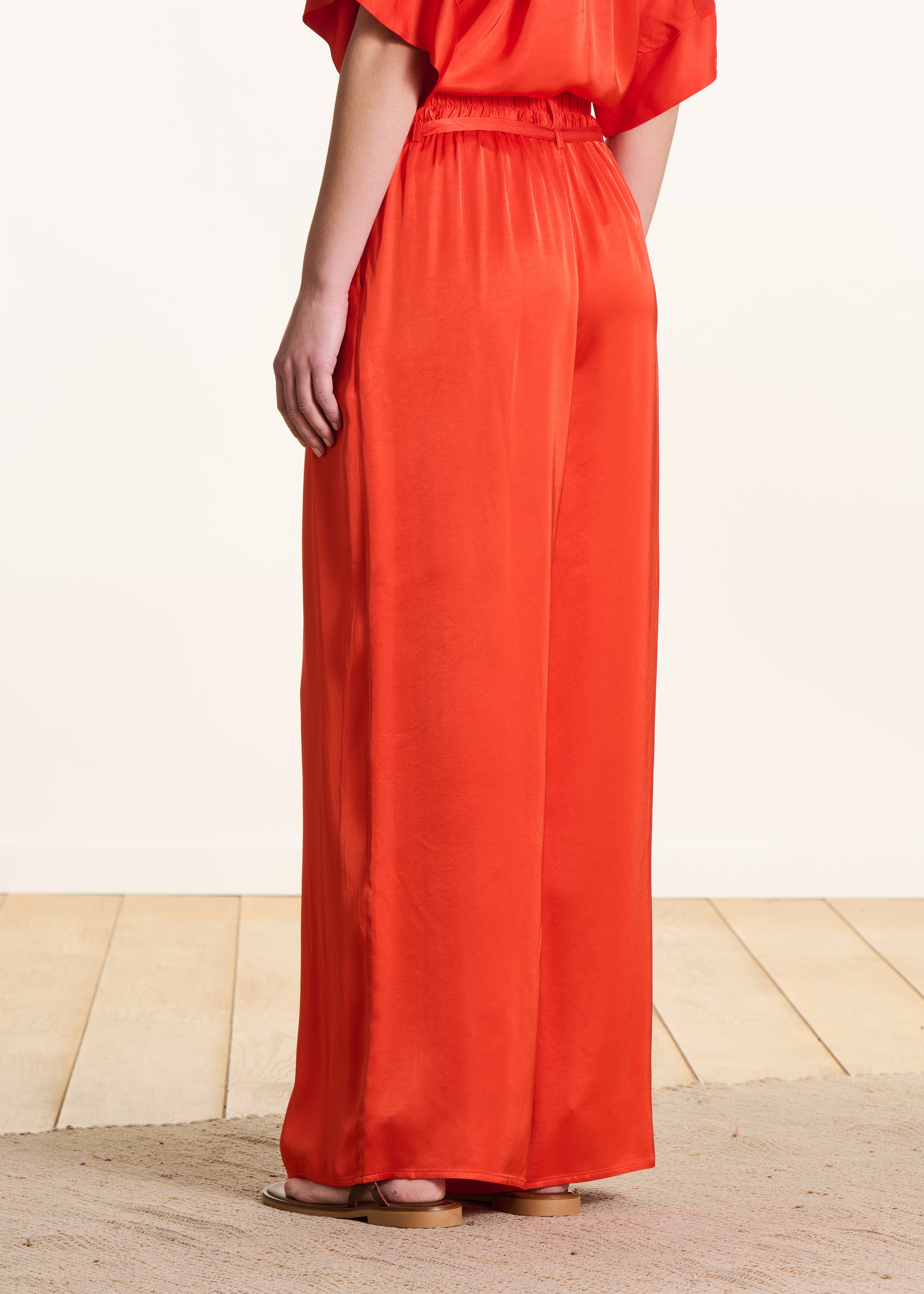 Wide high-waisted orange satin trousers
