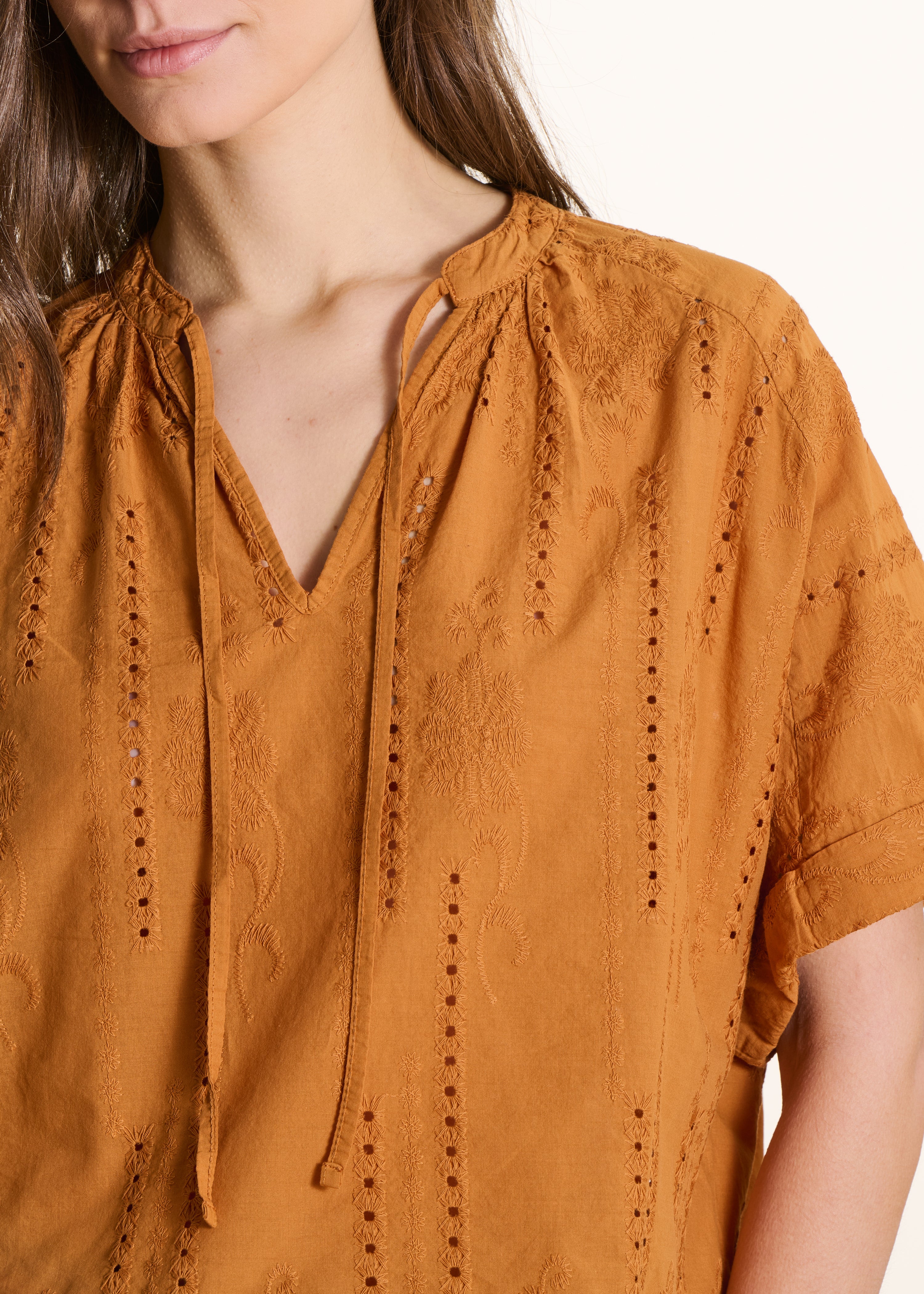 Losvallende okerkleurige blouse met Engelse borduursels