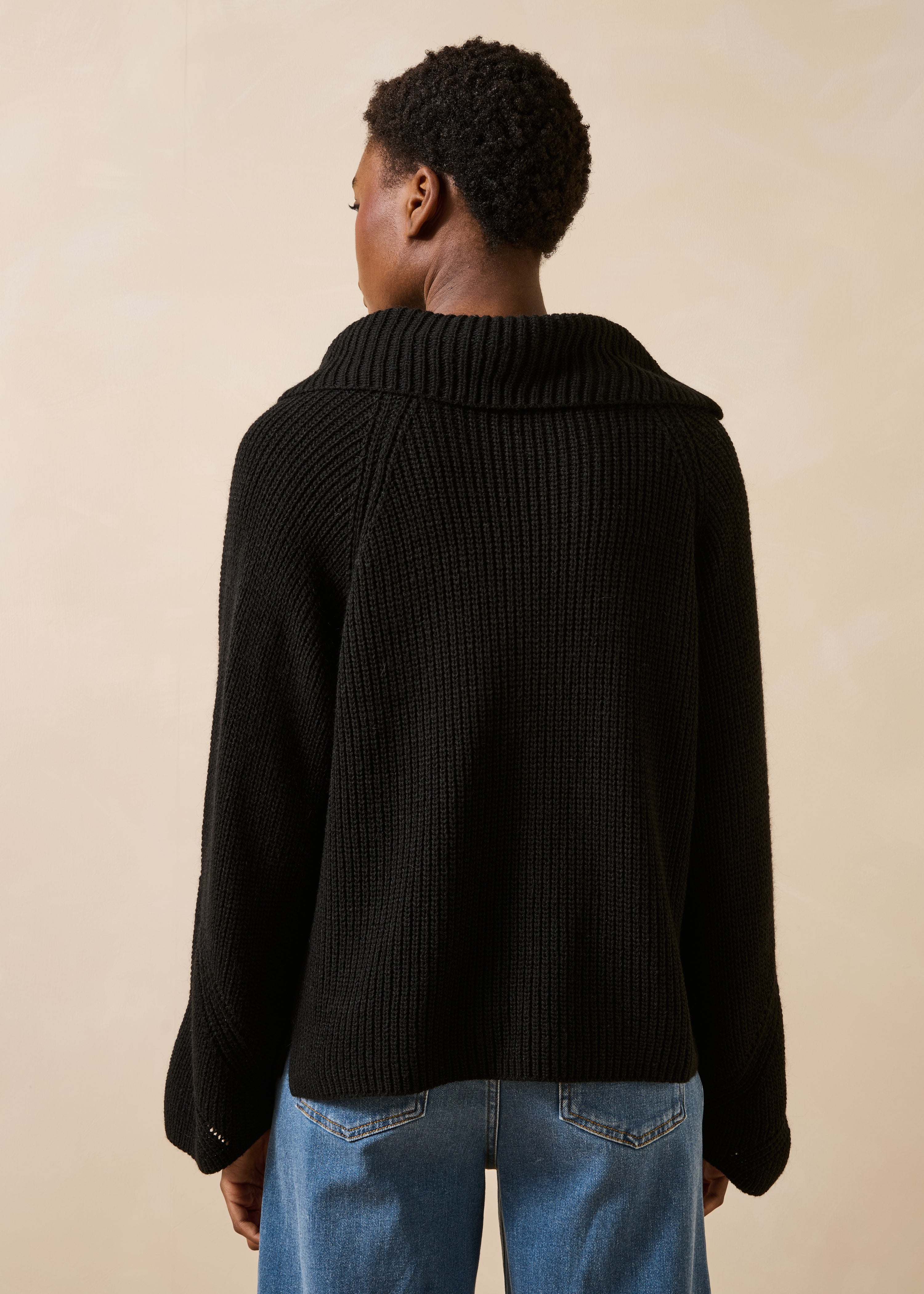 Maglione nero a maniche lunghe con collo asimmetrico