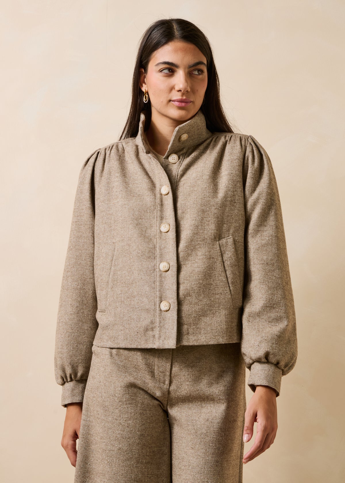Beige tweed jacket with long sleeves and a stand-up collar