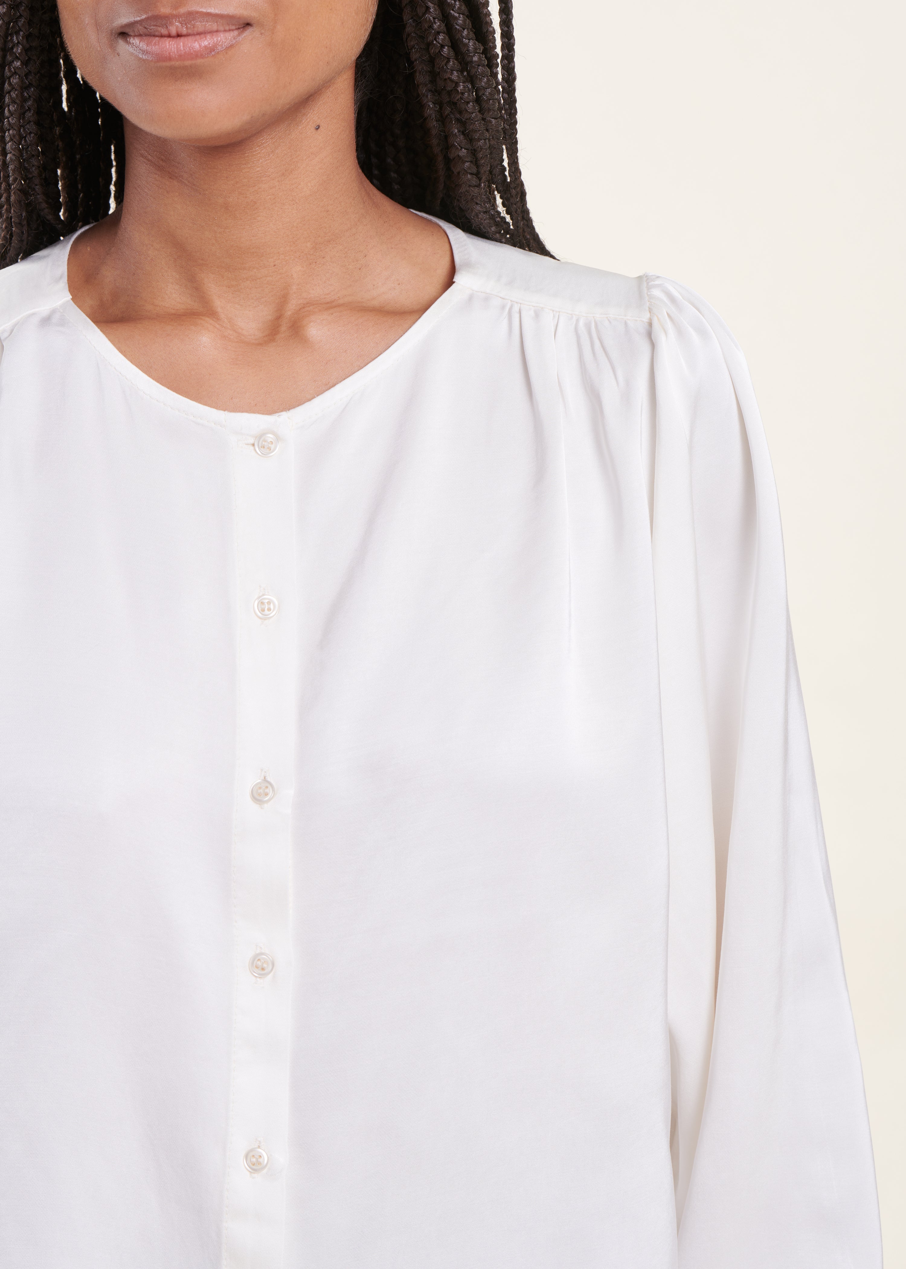 Loose white satin blouse with round neckline