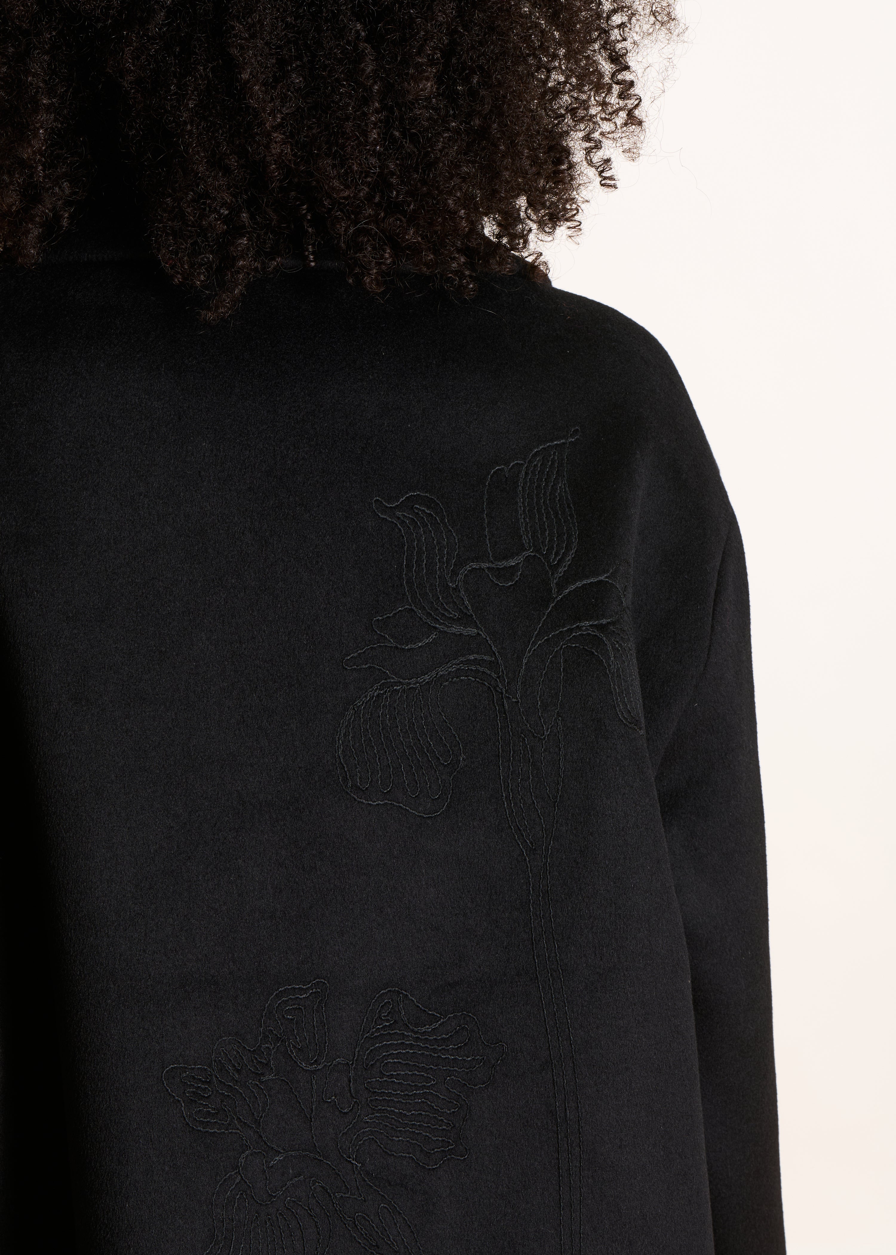 Halflange zwarte mantel met wollen borduurwerk