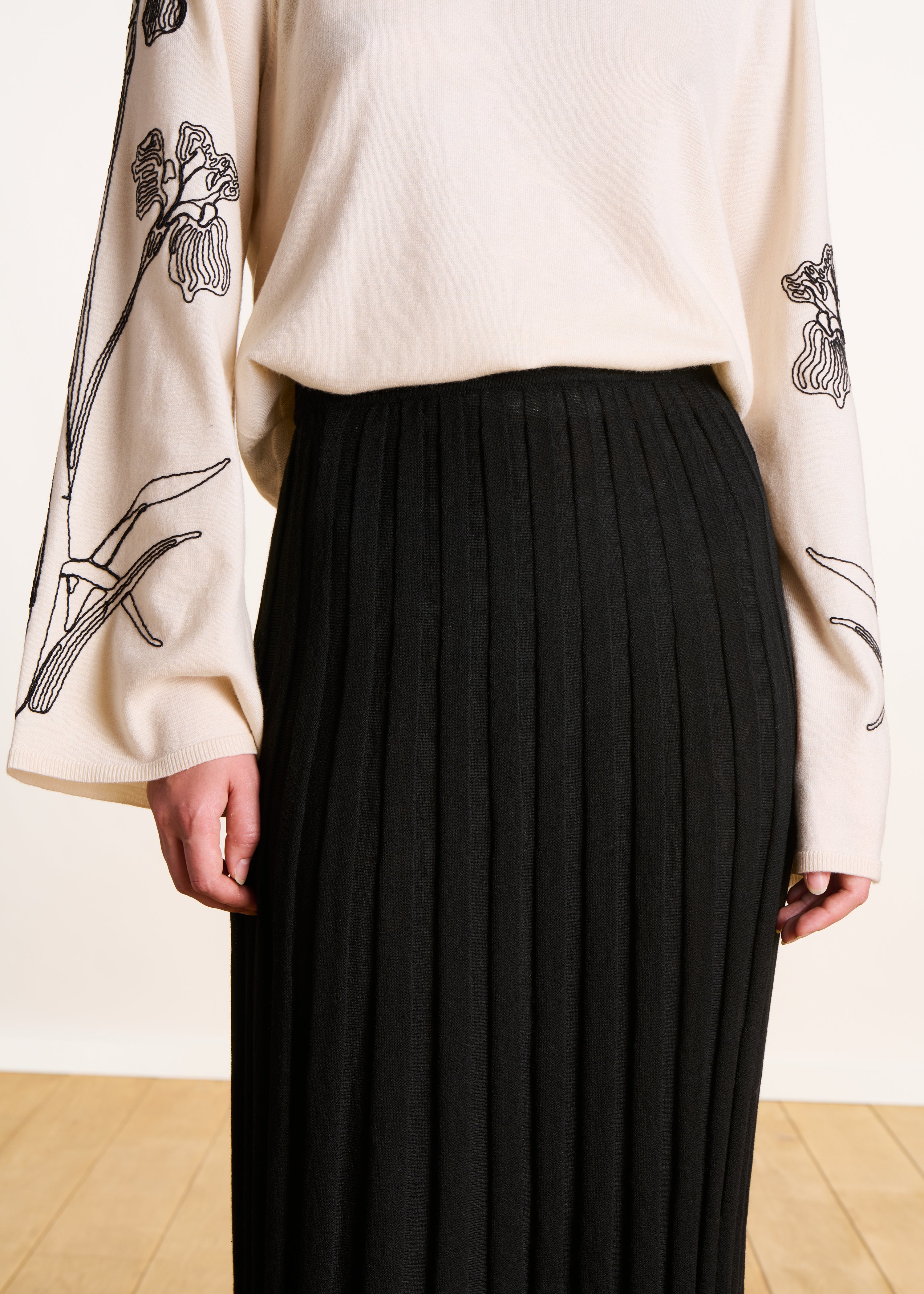 Jupe mi-longue noire en maille plissée