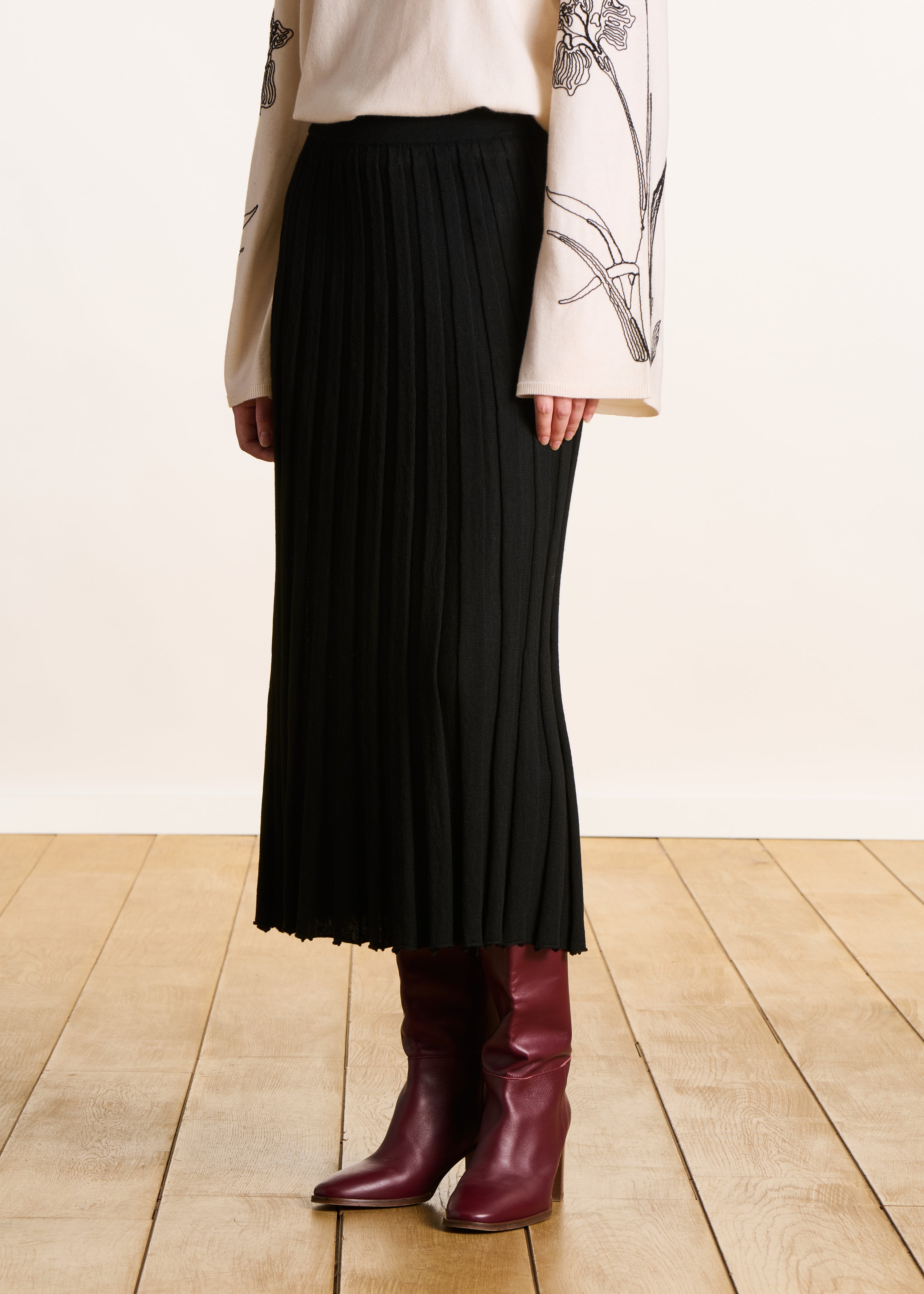 Jupe mi-longue noire en maille plissée