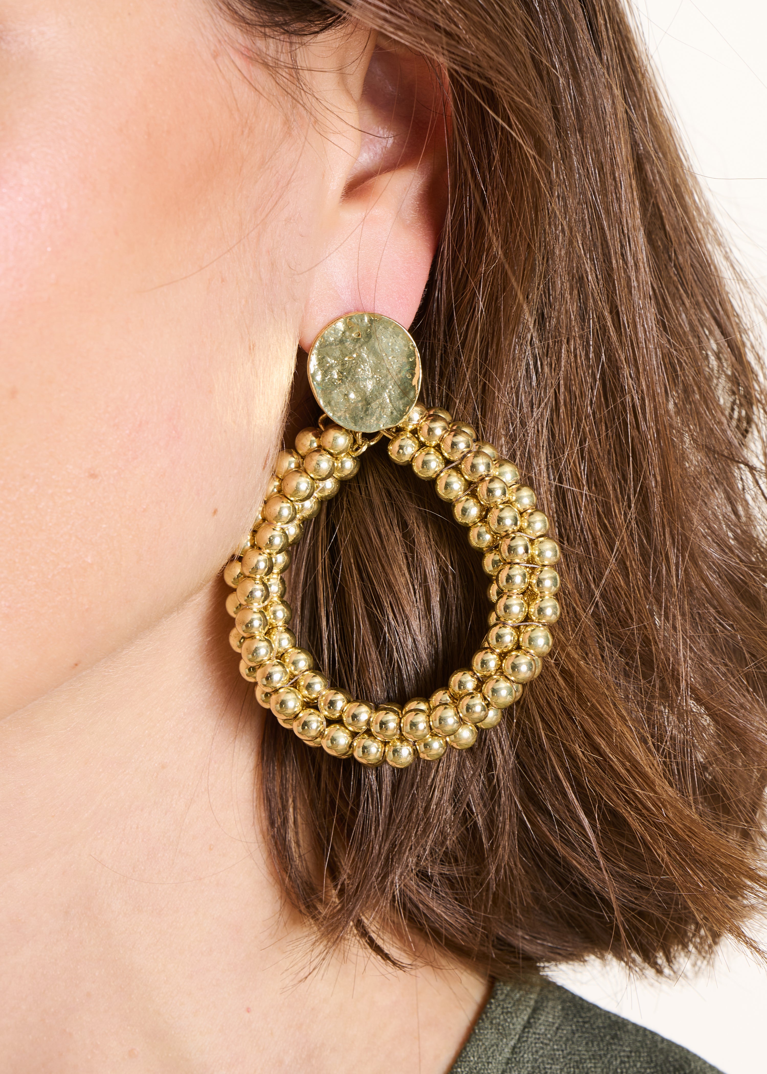 Goldene hängende Ohrringe mit Perlen