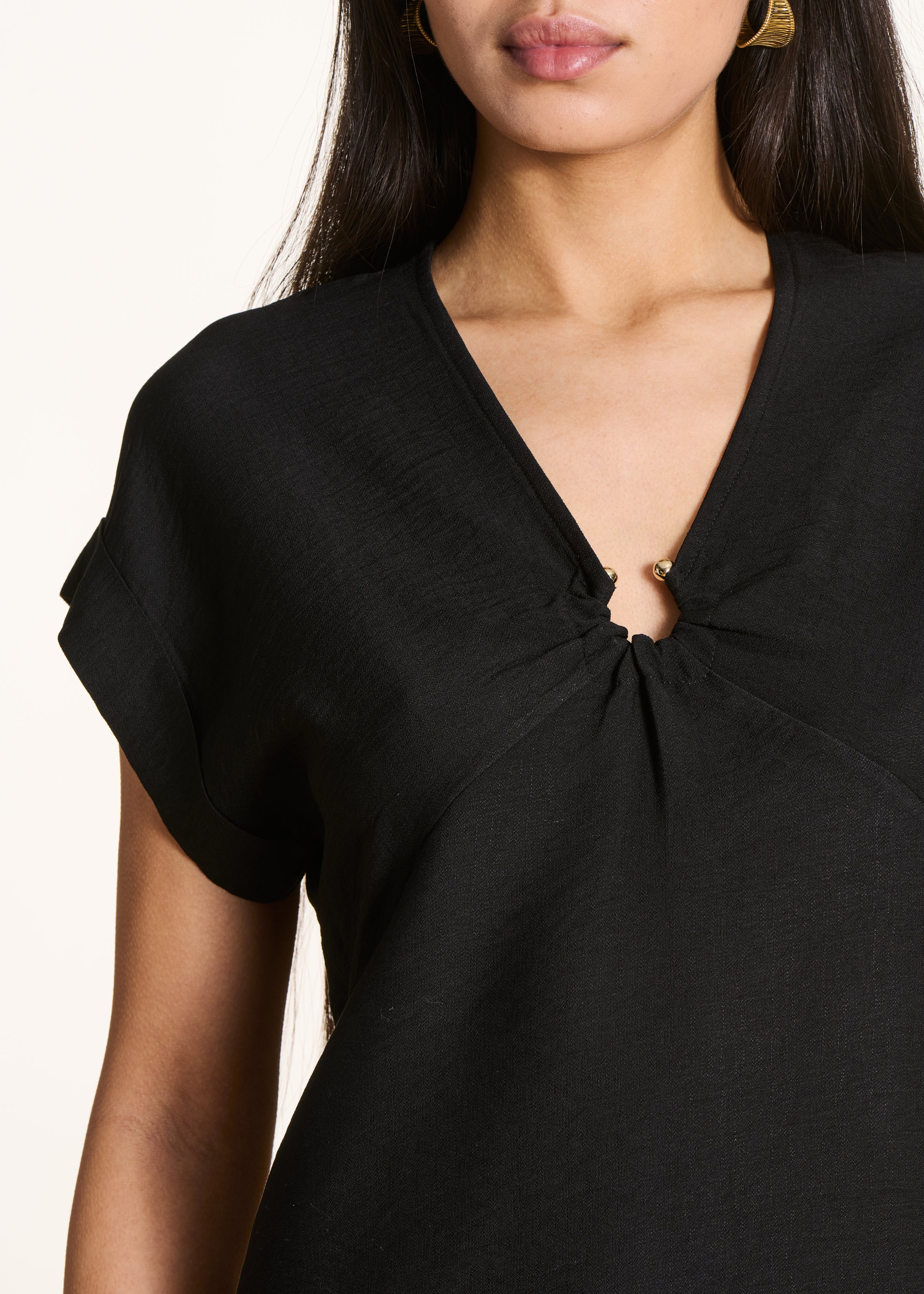 Kurzes schwarzes Kleid mit V-Ausschnitt und Schnalle