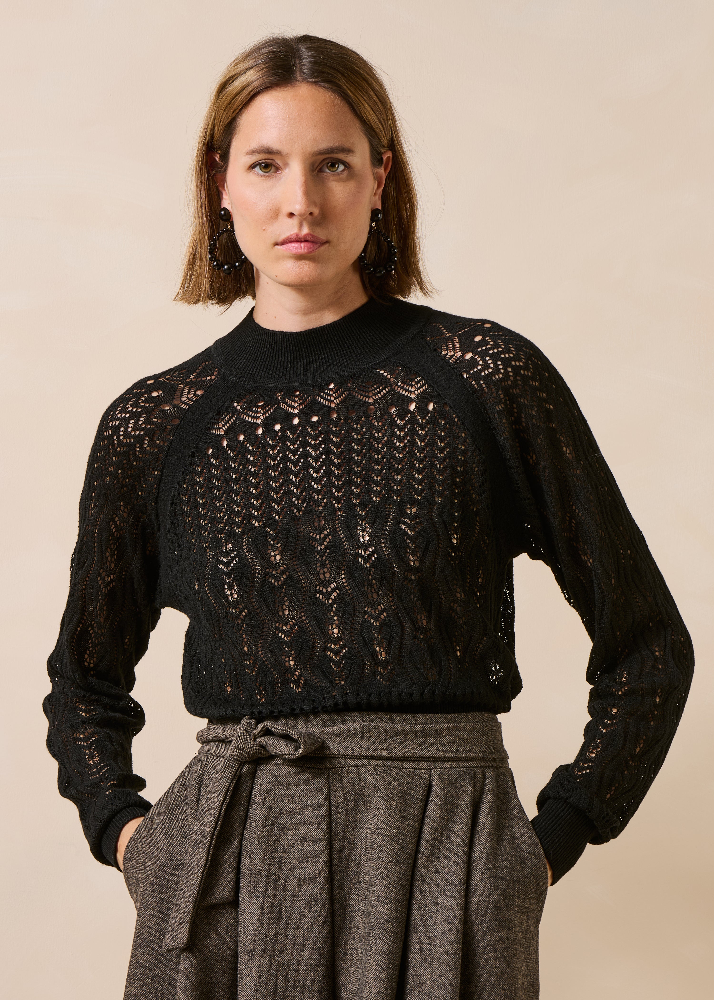 Black openwork knit sweater with long sleeves and mock neck