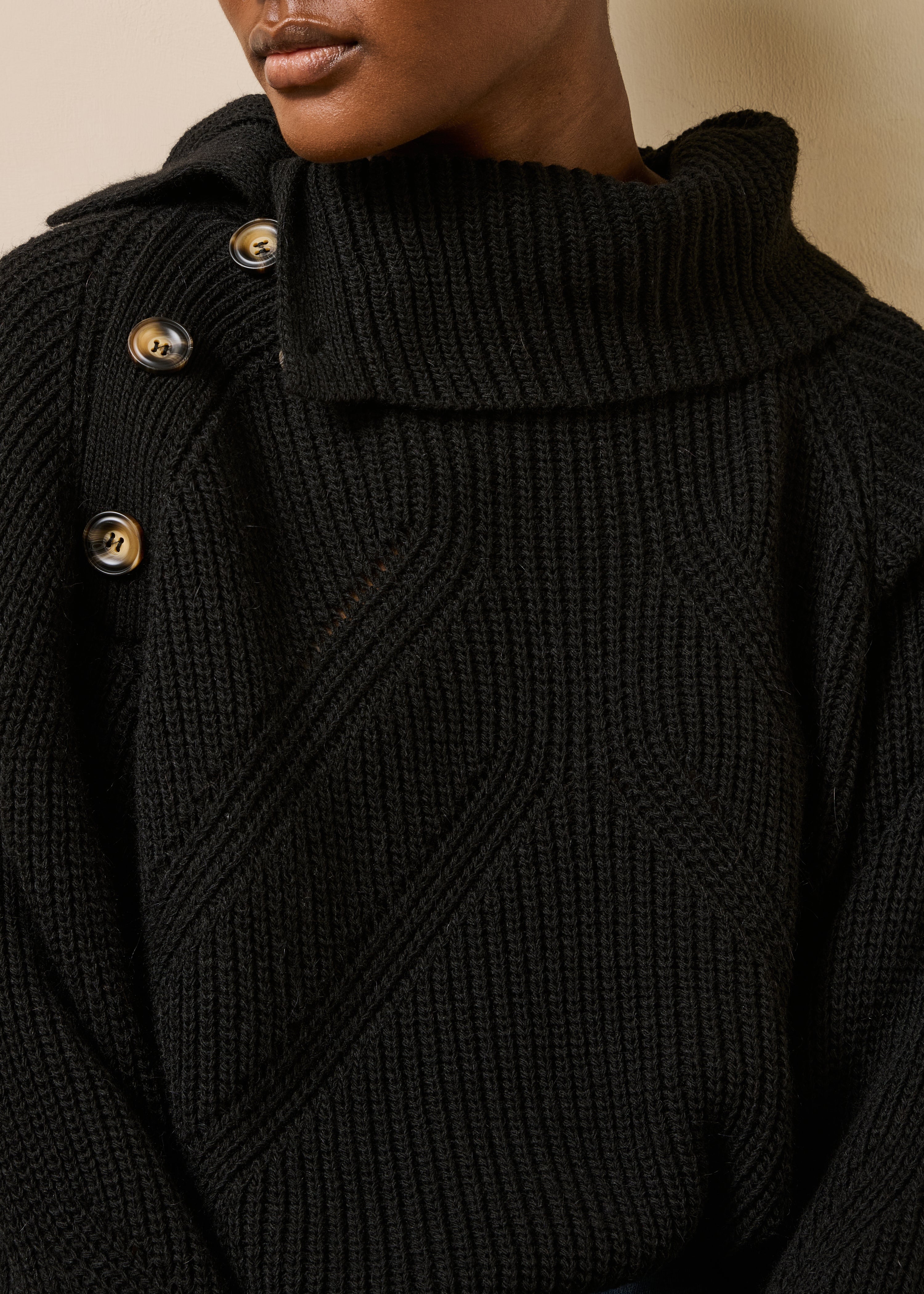 Maglione nero a maniche lunghe con collo asimmetrico