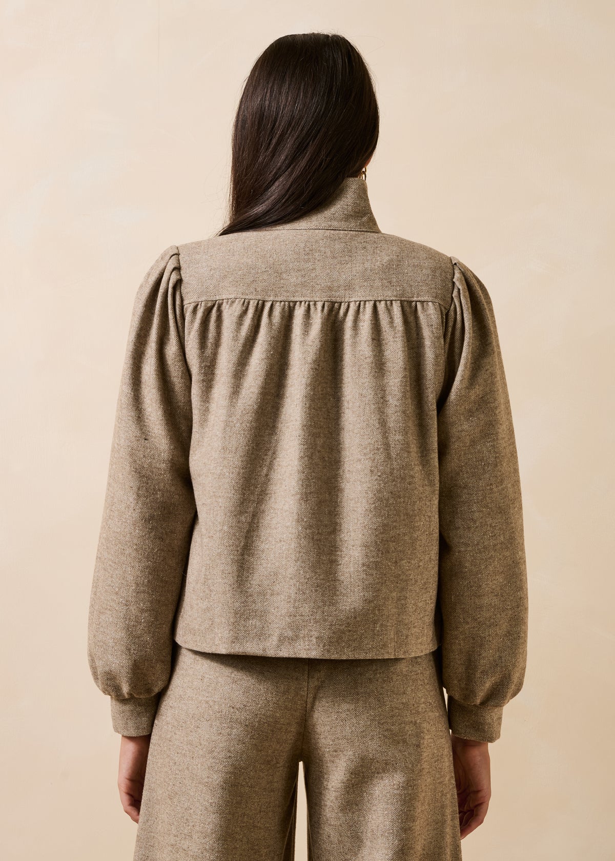 Beige tweed jacket with long sleeves and a stand-up collar